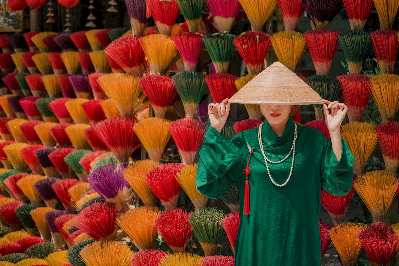 Colorful incense bundles and a visitor at one of Huế’s craft villages