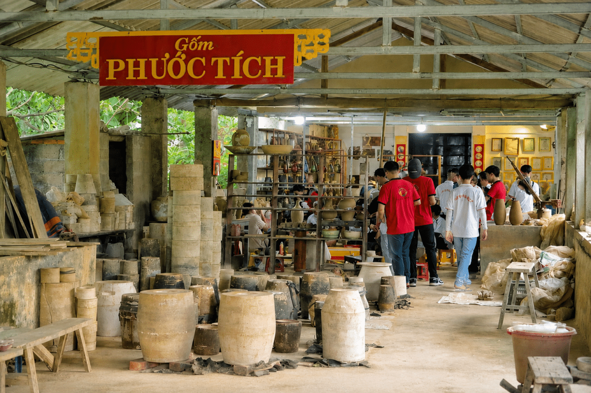 Pottery jars and visitors inside a Phước Tích workshop