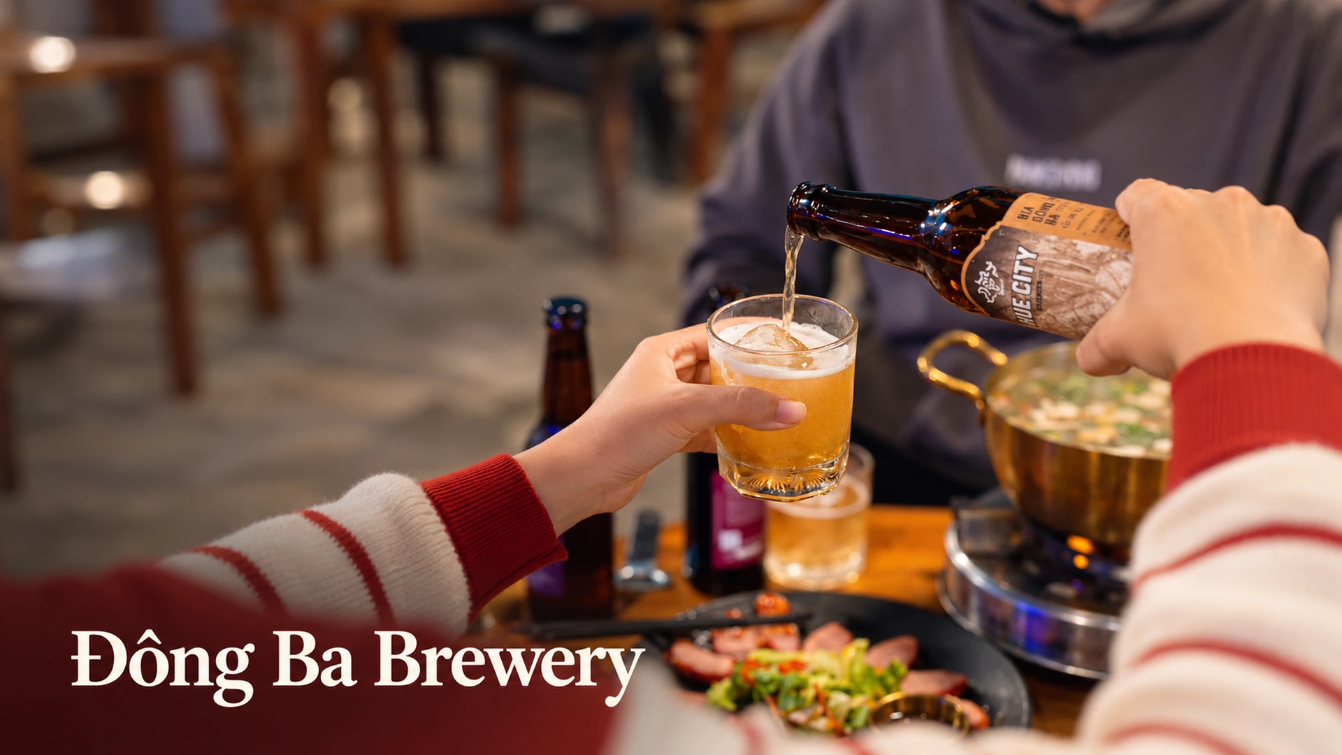 Rót bia Hue City từ chai vào ly bên bàn ăn tại Đông Ba