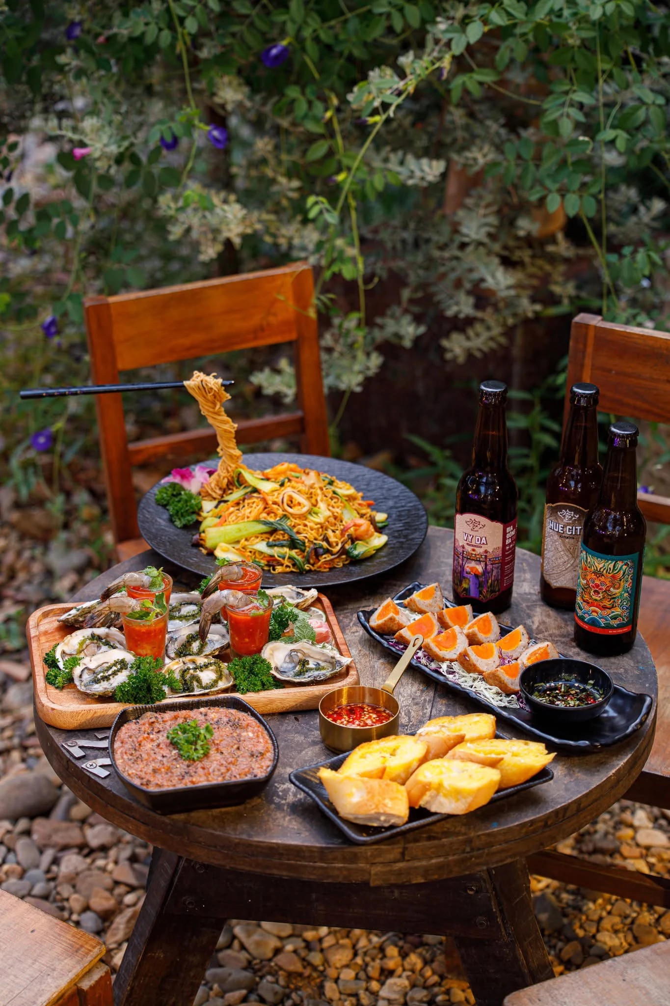 Food and Đông Ba beer on a garden table at the brewery
